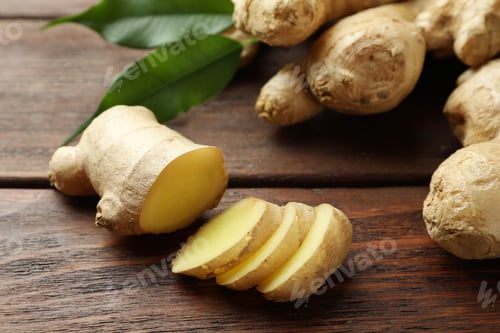 Preview: Cut and whole fresh ginger with leaves on wooden table, closeup
