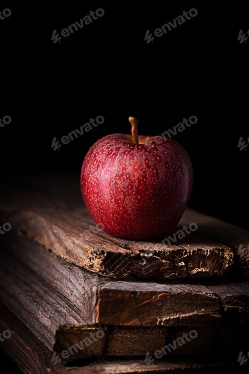 Preview: A red apple on black background, vertical
