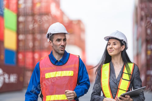 Preview: workers in high visibility safety gear and hard hats discuss operations