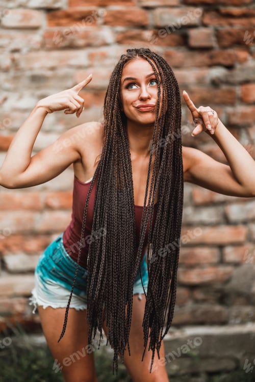Preview: Woman With Long Afro Braided Hair Having Fun Against A Brick Wall