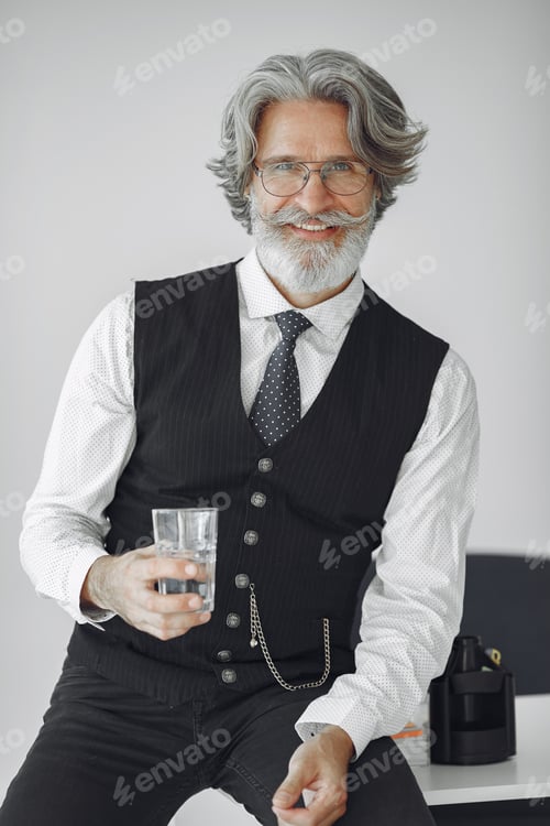 Preview: Handsome old businessman sitting with glass of water