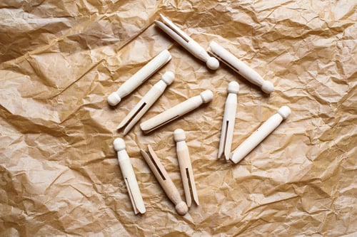 Preview: Old American style wooden clothespins for holding clothes, on a paper background.