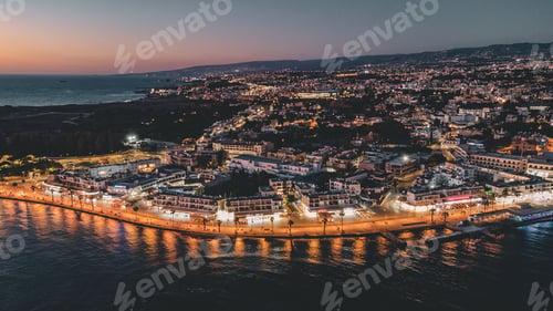 Preview: Coastal city at dusk with illuminated streets in Paphos, Cyprus.