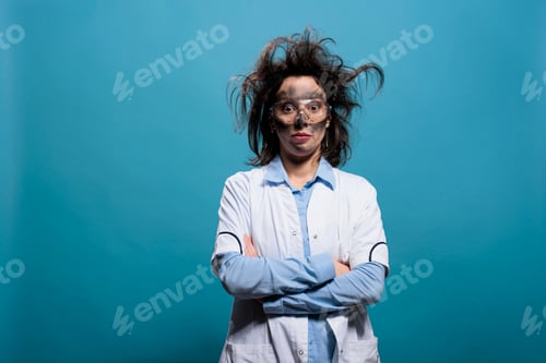 Preview: Humorous mad scientist with erratic hair and filthy face standing with crossed arms