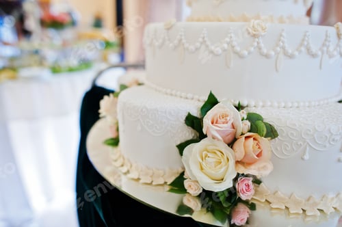 Preview: Close-up pgoto of deocorated with flowers beige wedding cake.