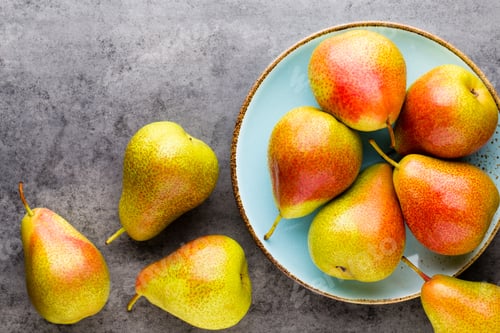 Preview: Fresh bio pear with leaves on the plate. Gray stone table.