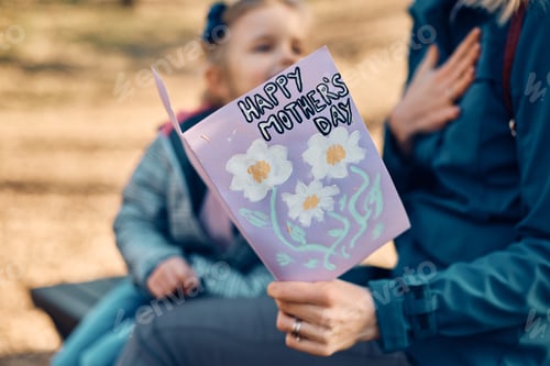 Preview: Close-up of mother receiving greeting card from her daughter on Mother's day.