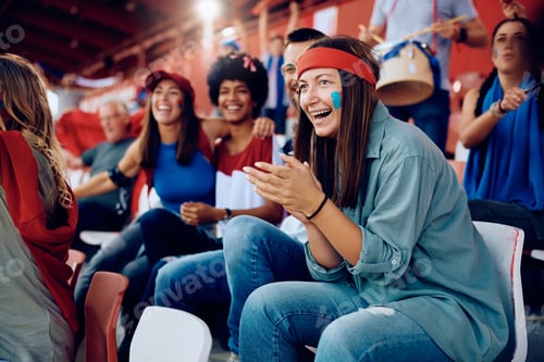 Preview: Happy woman and her friends having fun while watching sports championship at the stadium.