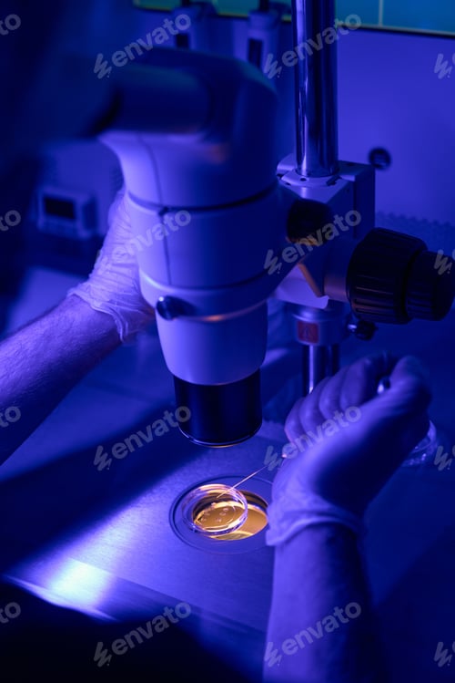 Preview: Genetic abnormalities laboratory worker examining cells under microscope