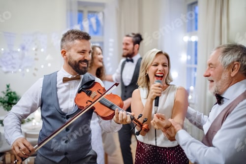 Preview: A young bride, groom and other guests dancing and singing on a wedding reception.
