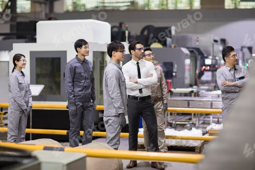 Preview: Confident businessman and engineering team in the factory