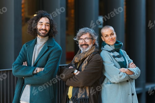 Preview: Business people looking at camera and smiling while posing with arms crossed outdoors on the street