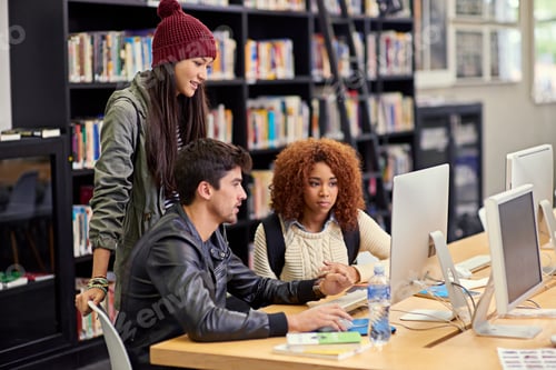 Preview: Shot of a group of students working together at a computer in a university library