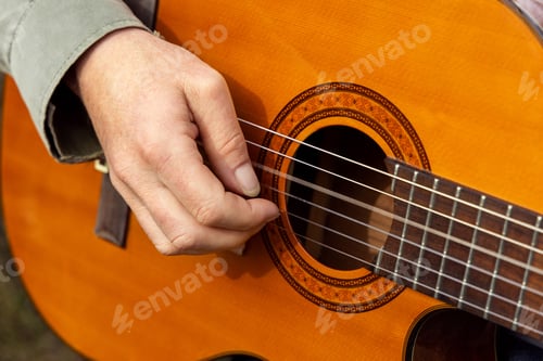 Preview: Male hands playing acoustic guitar, close up. Teacher is giving guitar lesson