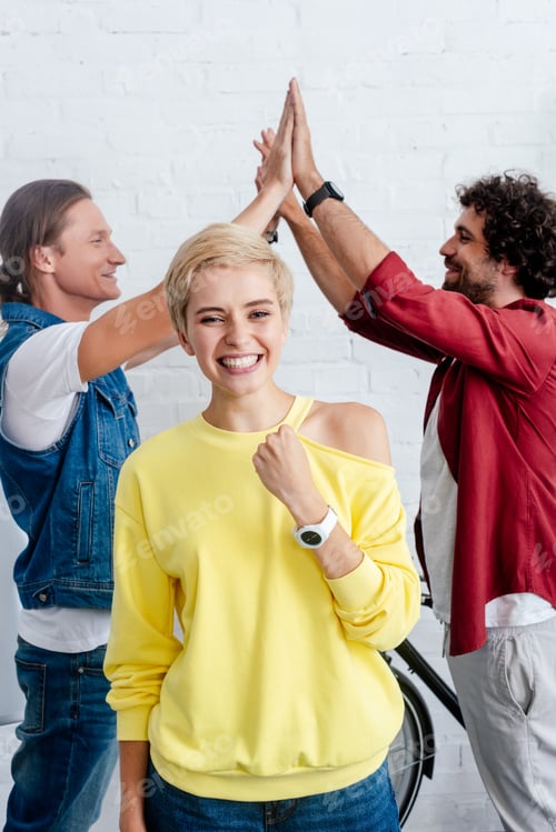 Preview: cheerful young business colleagues triumphing in office