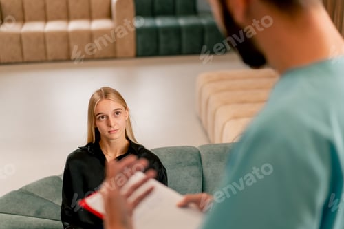 Preview: A girl patient listens attentively to her doctor while sitting in the corridor of a medical center