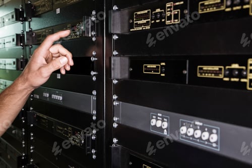 Preview: Close up of the hand of a technician working on a server in a large computer server room.