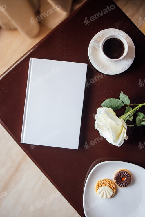 Preview: White book mock up placed on a wooden table beside a cup of coffee