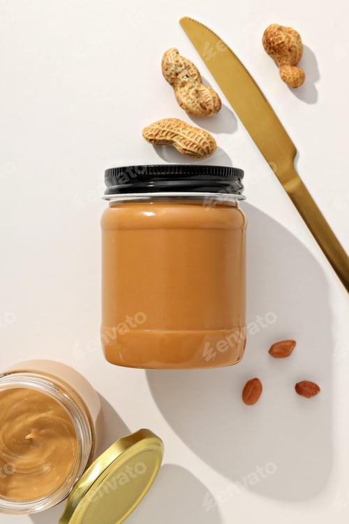 Preview: Peanut paste in a glass jar, on a light background.