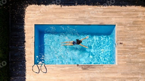 Preview: Female swimming in pool water on sunny summer day