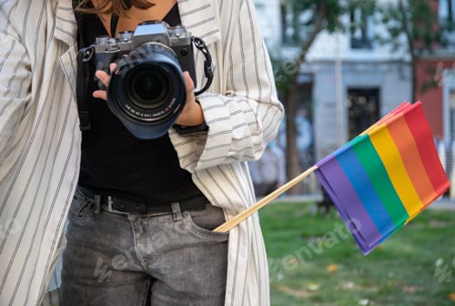 Preview: Woman with photo camera and rainbow flag in city