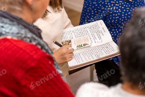 Preview: Soy candle creation workshop. Women writing down the indications of the candle making process.
