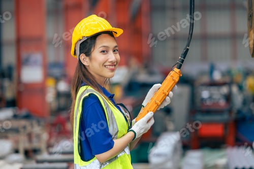 Preview: Young Asian woman engineer worker happy smiling professional working in heavy industry plant factory