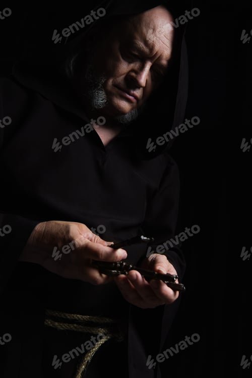 Preview: medieval monk in hooded cassock holding keys isolated on black