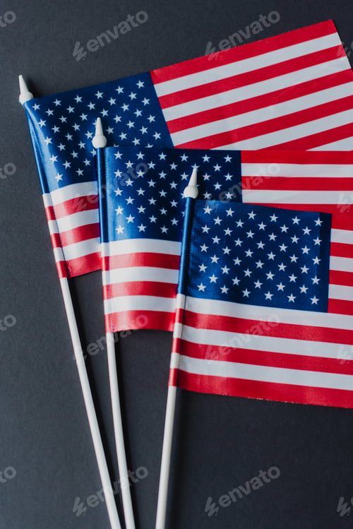 Preview: top view of three flags of Unites States with stars and stripes isolated on black