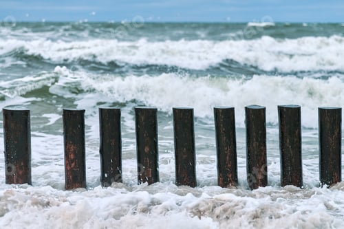 Preview: High wooden breakwaters in foaming sea waves
