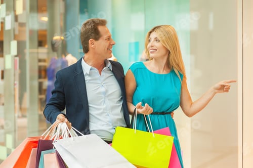 Preview: Look at this dress! Beautiful mature couple shopping together while woman pointing away and smiling