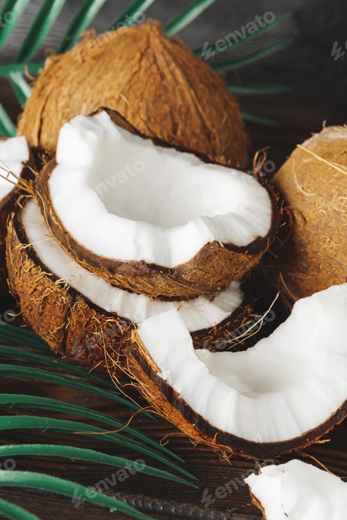 Preview: Cracked coconut pieces on dark wooden background