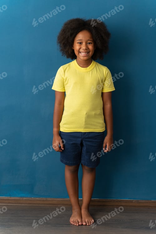 Preview: Portrait of cute little girl with stylish curly hairdo in yellow T-shirt standing