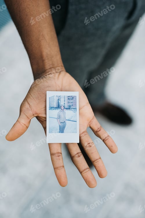 Preview: Close up hand of young black man showing a photo