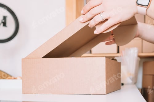 Preview: Cropped photo of woman hands packing, preparing parcel for delivery package to customers. Small