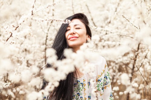 Preview: Beautiful young woman in blooming cherry blossoms garden.