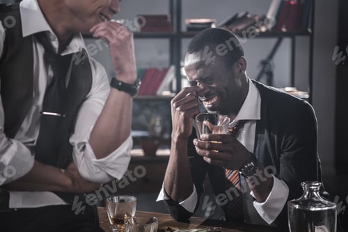 Preview: cheerful colleagues drinking alcohol while spending time together after work