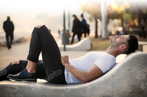 Preview: Man lying near the sea on a bench