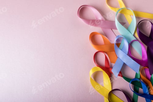 Preview: Directly above shot of various colorful awareness ribbons on pink background, copy space