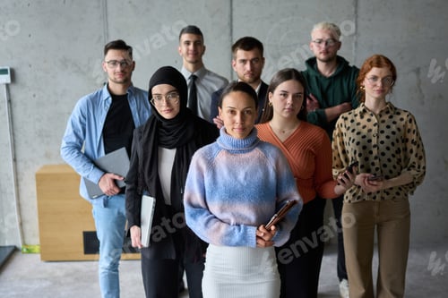 Preview: A diverse and determined team of business professionals stands confidently in an office, ready to