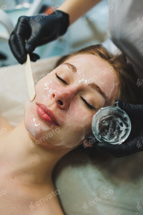 Preview: The hands of a beautician apply a mask to a woman's face in a spa salon. Aesthetic procedure