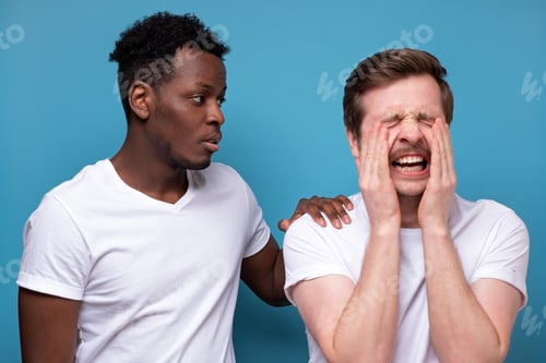 Preview: African american man calms down his colleague or friend, who has troubles