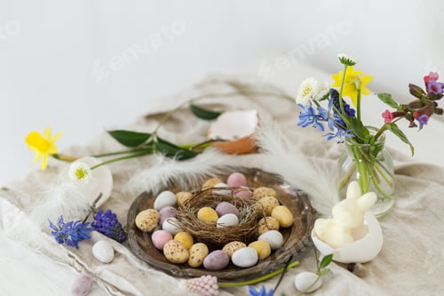 Preview: Happy Easter! Stylish easter chocolate eggs in nest, spring flowers, feathers and linen cloth
