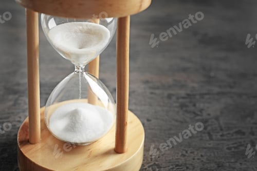 Preview: Hourglass with flowing sand on table. Time management