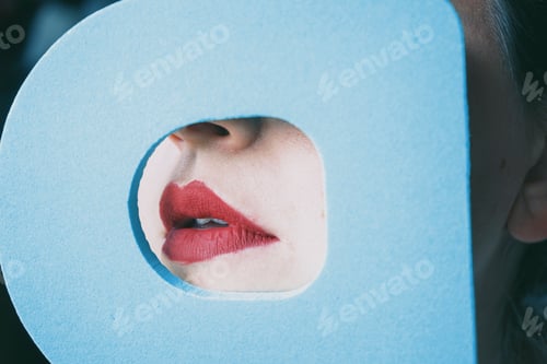 Preview: Young woman red lips behind a cover blue circle