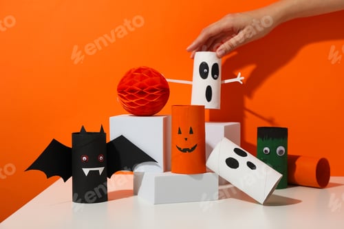 Preview: Paper Halloween mockups on table and female hand on orange background