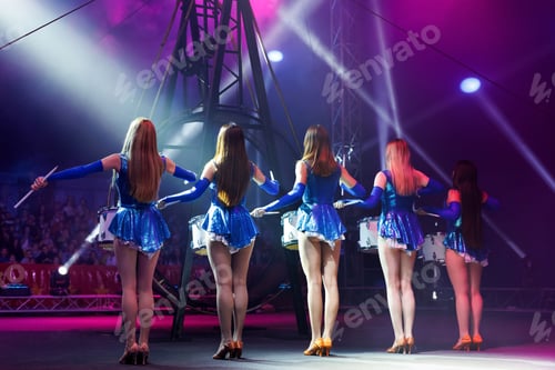 Preview: Female drummers in the circus arena in the spotlight and in the smoke. Rear view.