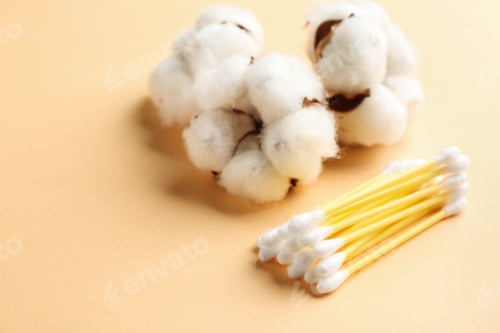 Preview: Cotton swabs and flowers on color background, closeup. Space for text