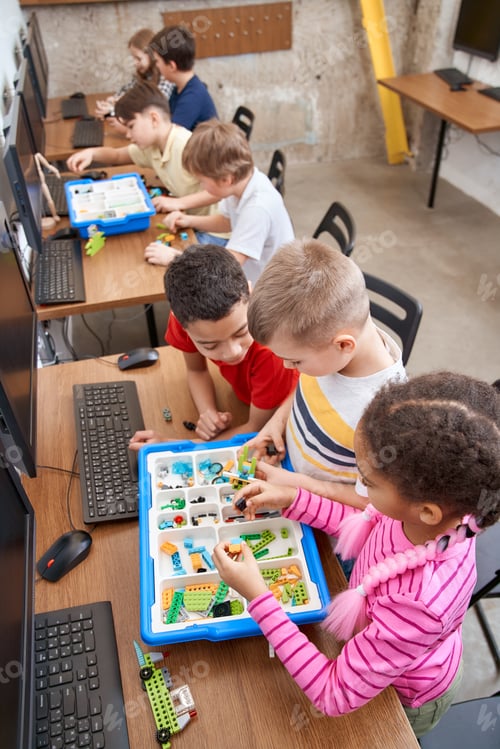 Preview: Young friends having fun, using building kit