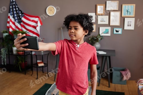 Preview: Boy making selfie portrait on his smartphone